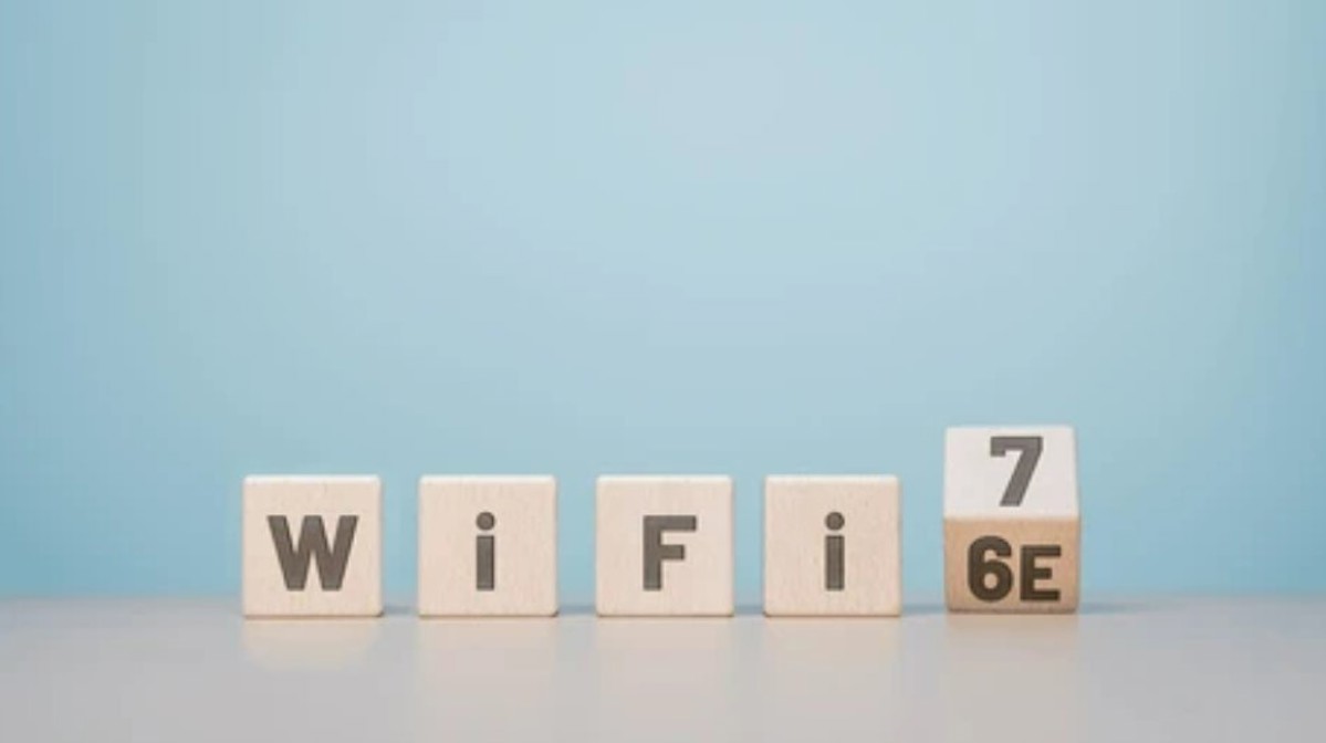 Wooden blocks spell out Wi-Fi 6E, with the last block turning over to reveal Wi-Fi 7